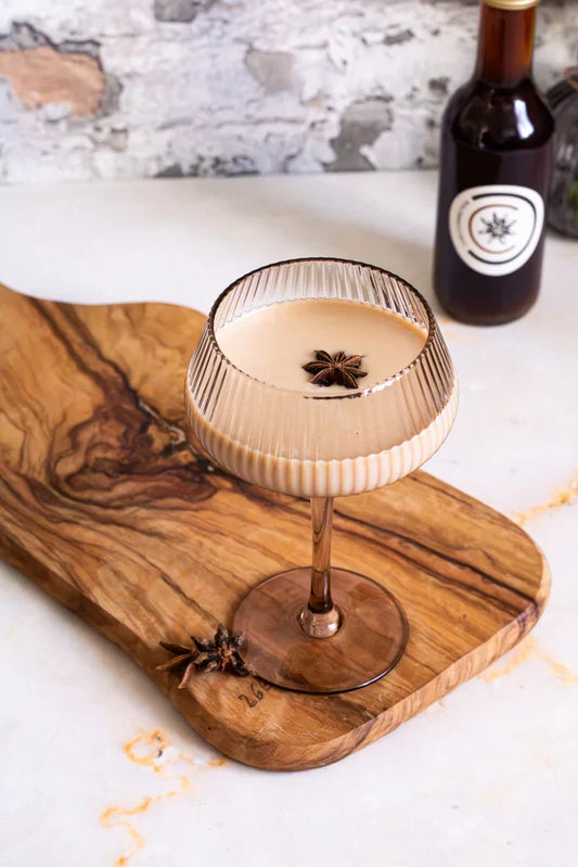 Chai Connection Cocktail mit Chai-Konzentrat, Baileys und Vodka, serviert im Glas mit Sternanis – cremiger Winterdrink