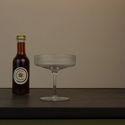 Chai Connection (Geschenk-) Flasche mit Chai-Sirup – Chai Konzentrat neben Cocktailglas, produziert in der Schweiz für Chai Lattes, Cocktails und viele kreative Rezepte. 
