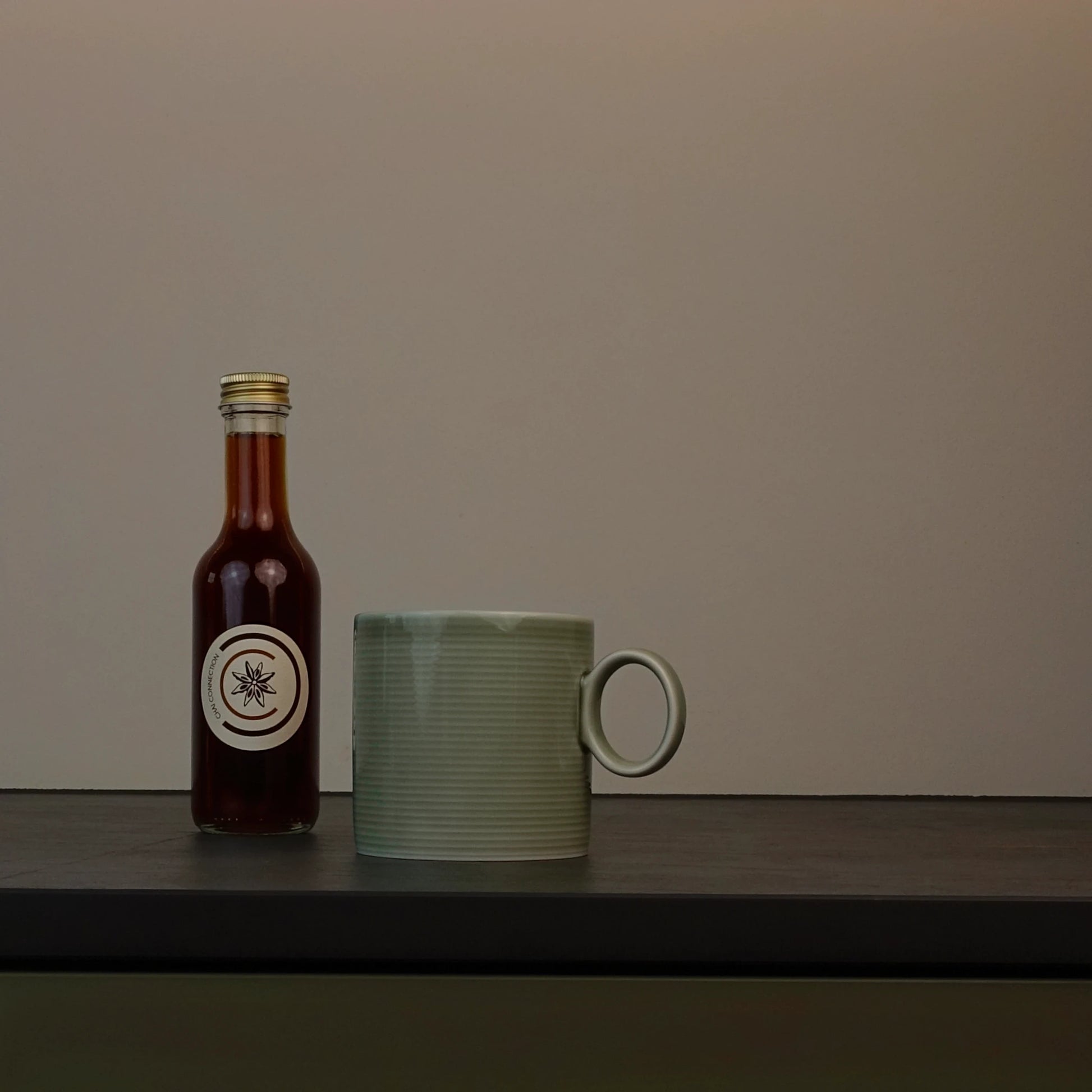 Chai Connection (Geschenk-) Flasche mit Chai-Sirup – Chai Konzentrat neben grüner Tasse, produziert in der Schweiz für Chai Lattes, Cocktails und viele kreative Rezepte. 