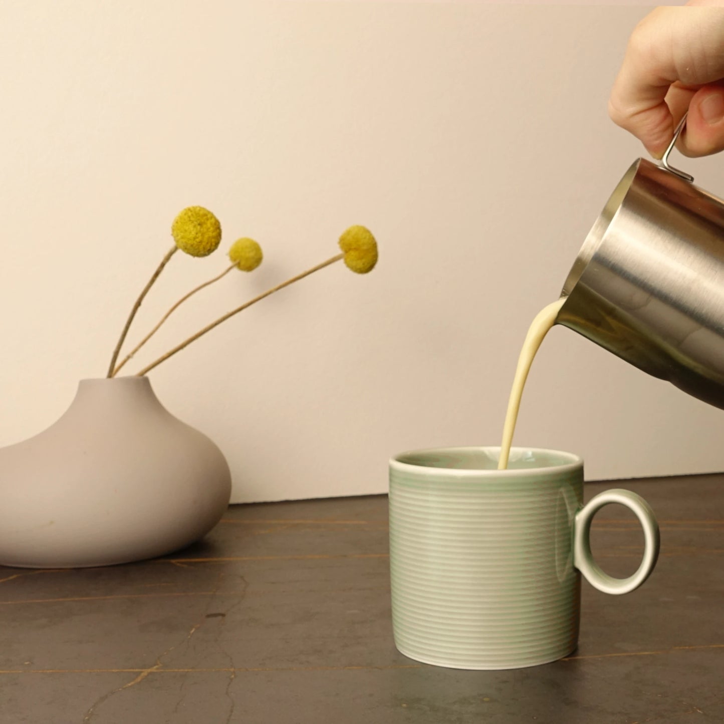 Milch wird auf den Chai Sirup in eine Keramiktasse gegossen – für warmen, leckeren Chai Latte“